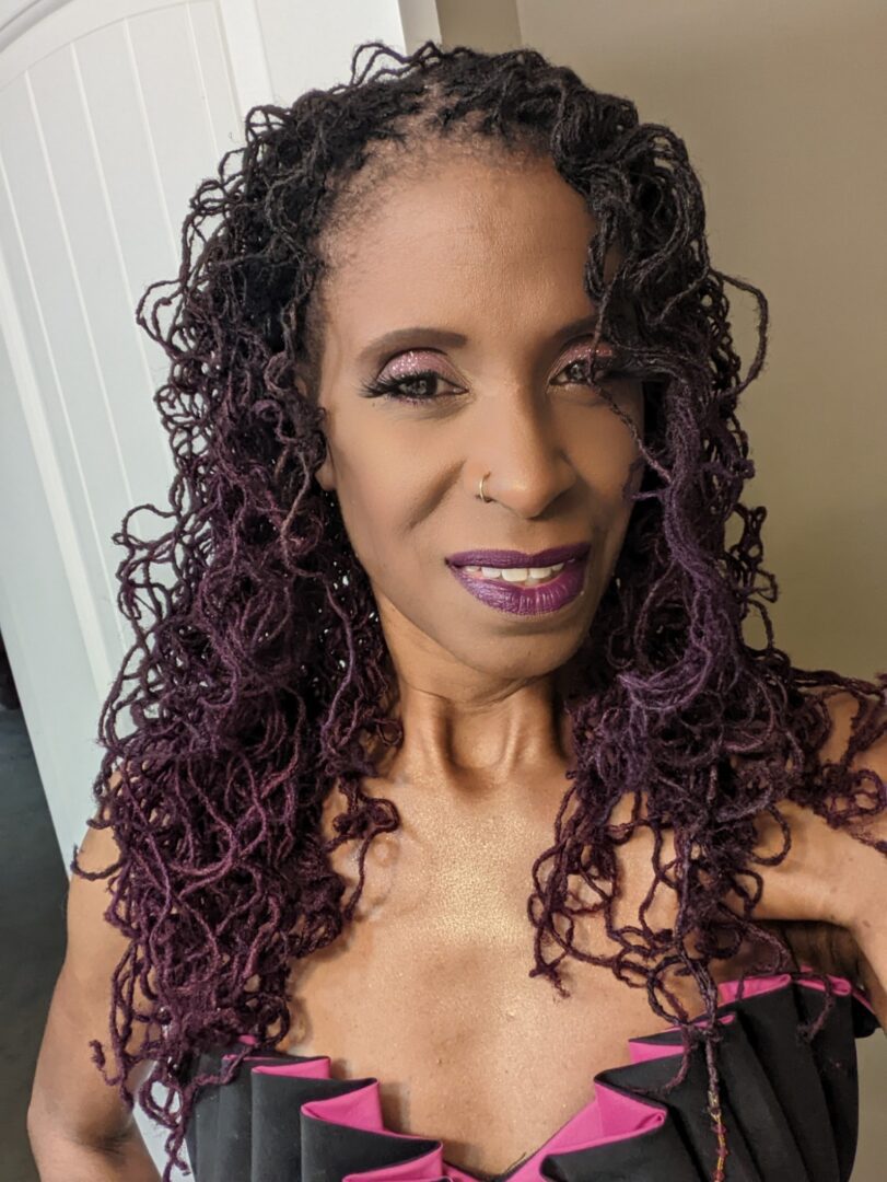 A woman with purple hair and a black top